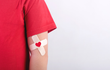 A person in a red shirt with bandages on their arm
