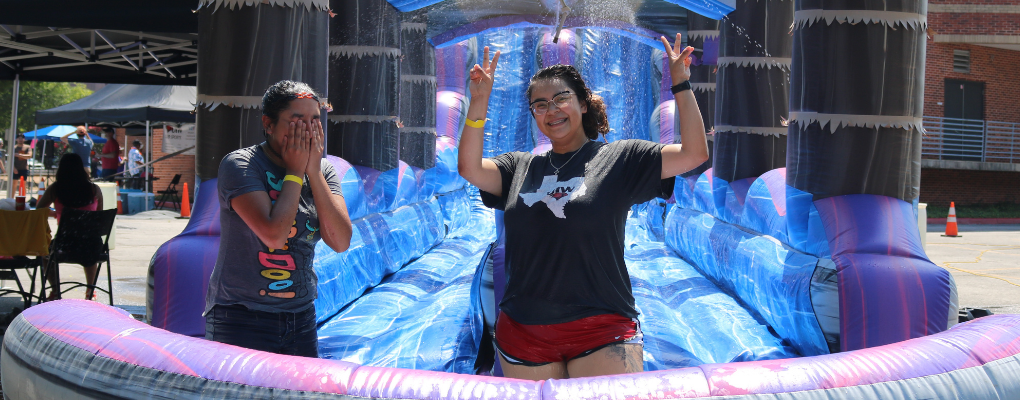A student smiles in a water slide pool