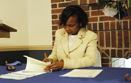 Ivy Taylor signs documents