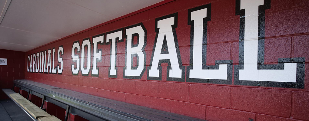 A wall in a locker room is painted to say "Cardinal Softball"