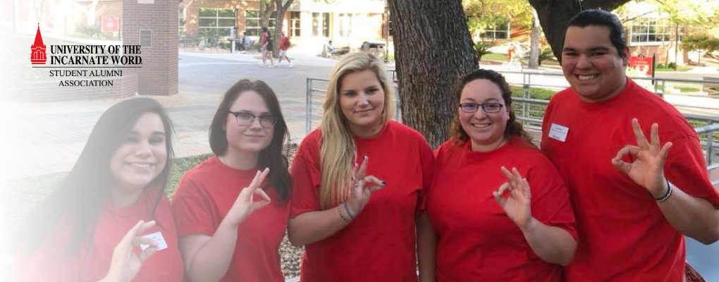 UIW students pose for a photo with the Cardinal hand sign