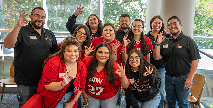 Admissions counselors giving the Cardinal hand sign