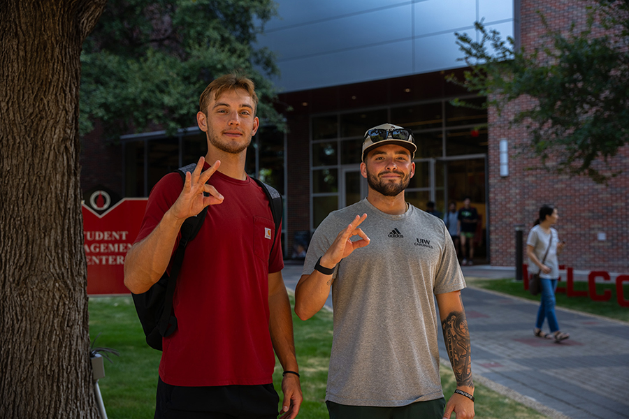 Two students making the Cardinal hand sign