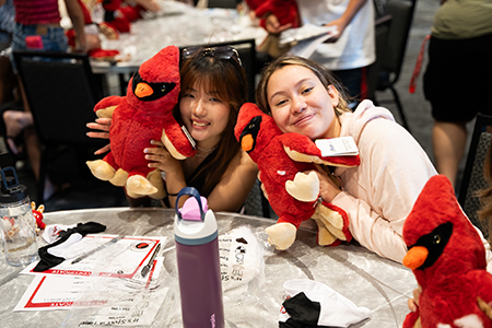 Text "Upcoming admissions events" over photo of two students with stuffed cardinals