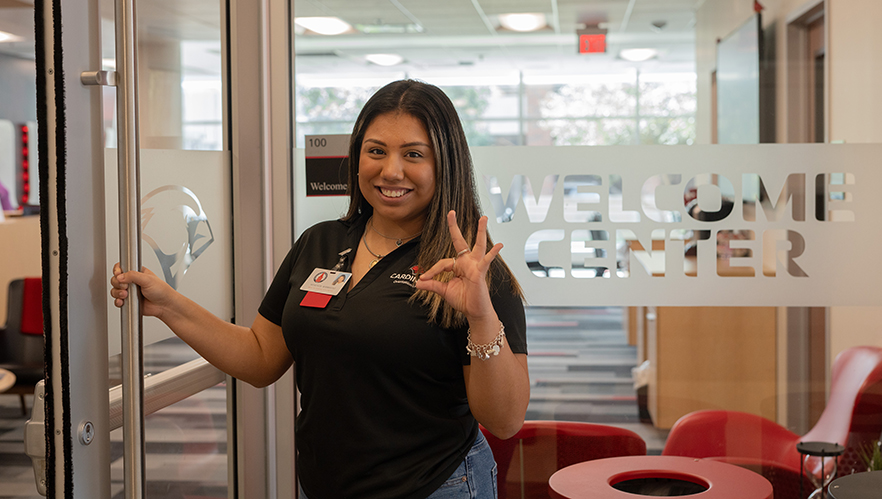 Orientation Leader standing by the Welcome Center door