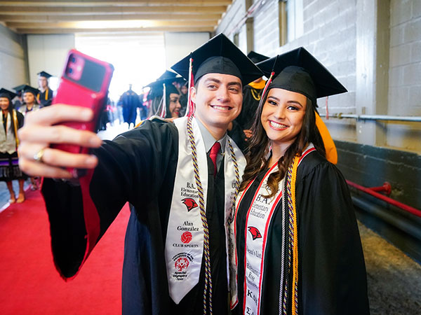 two student taking photos at graduation