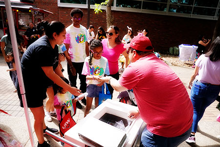 Alumnus handing food to child
