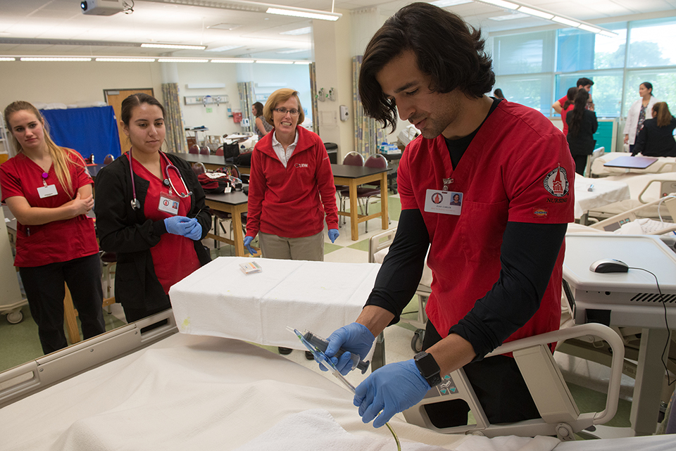 Nursing students around a hospital bed