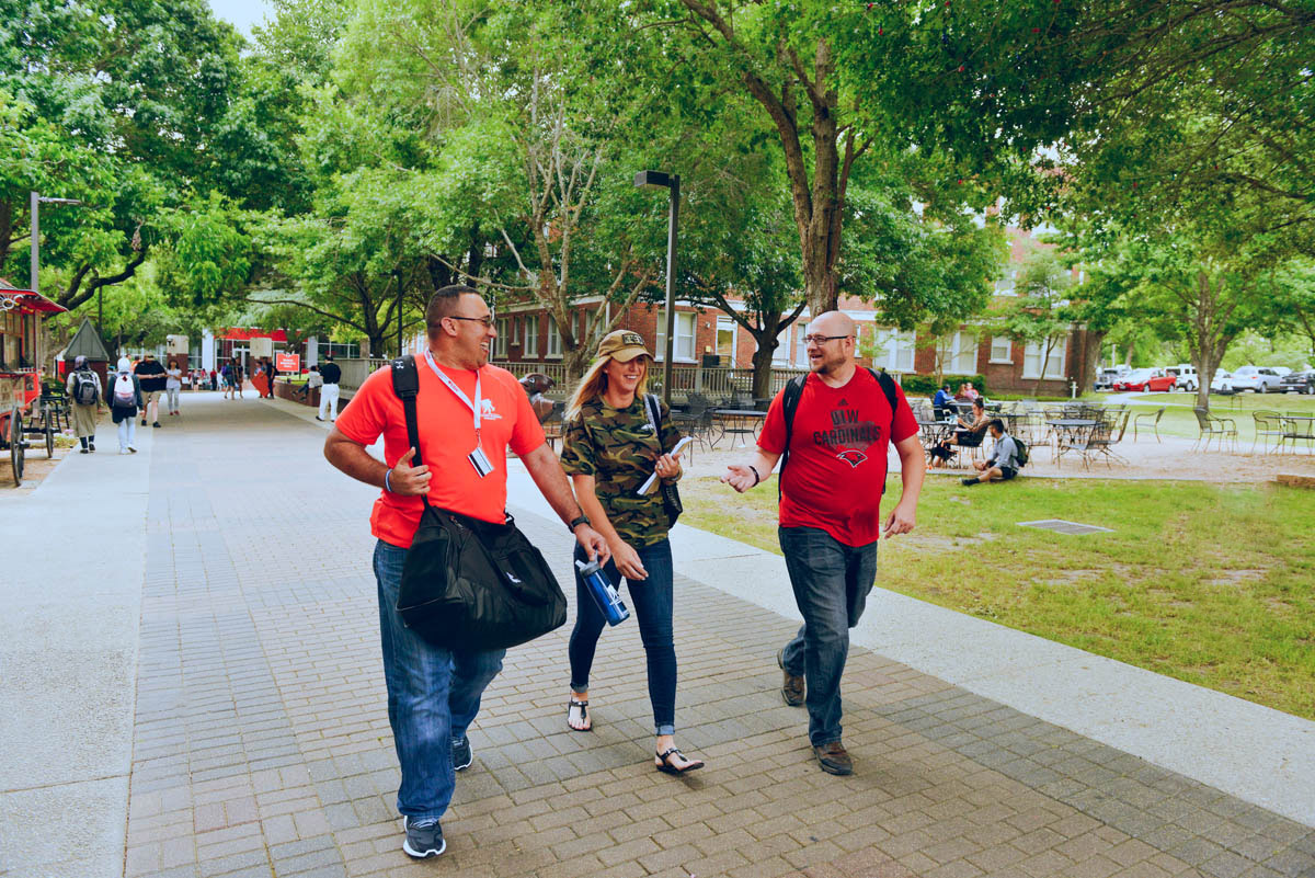 Three students walking across campus