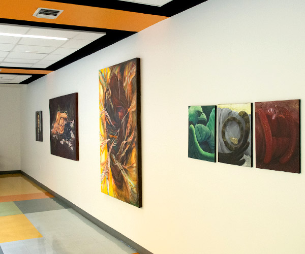 Paintings hanging by the entrance to a university art gallery