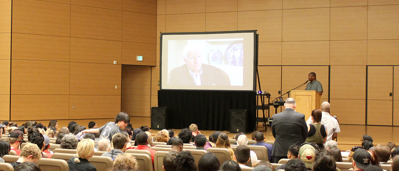 Speaker presenting to an auditorium full of people