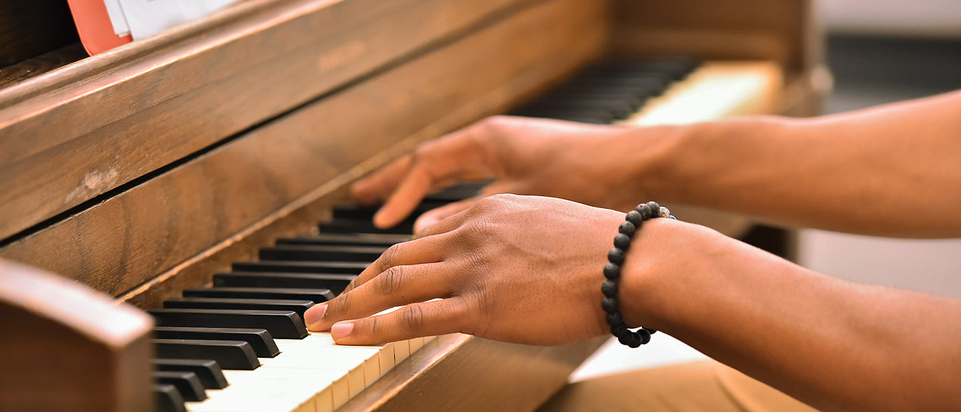 Close up of music student's hands playing the piano
