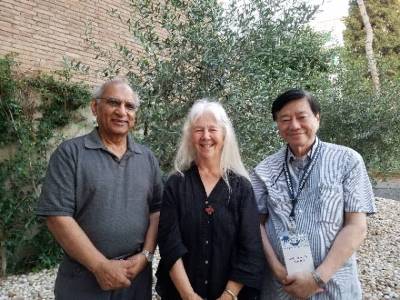 Sr. Marth Ann Kirk with Dr. Piyush Swami and Dr. Toh Swee-Hin standing in front of an olive tree.