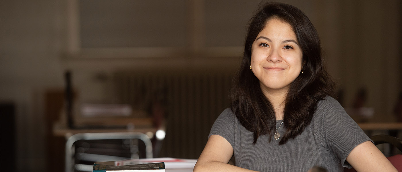 Student sitting at her desk in a classroom.