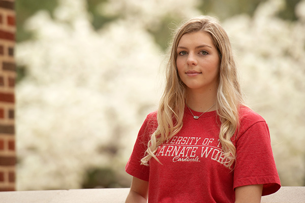 Close up of student on campus with blooming flowers in the background