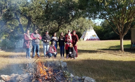 Campfire with students behind it