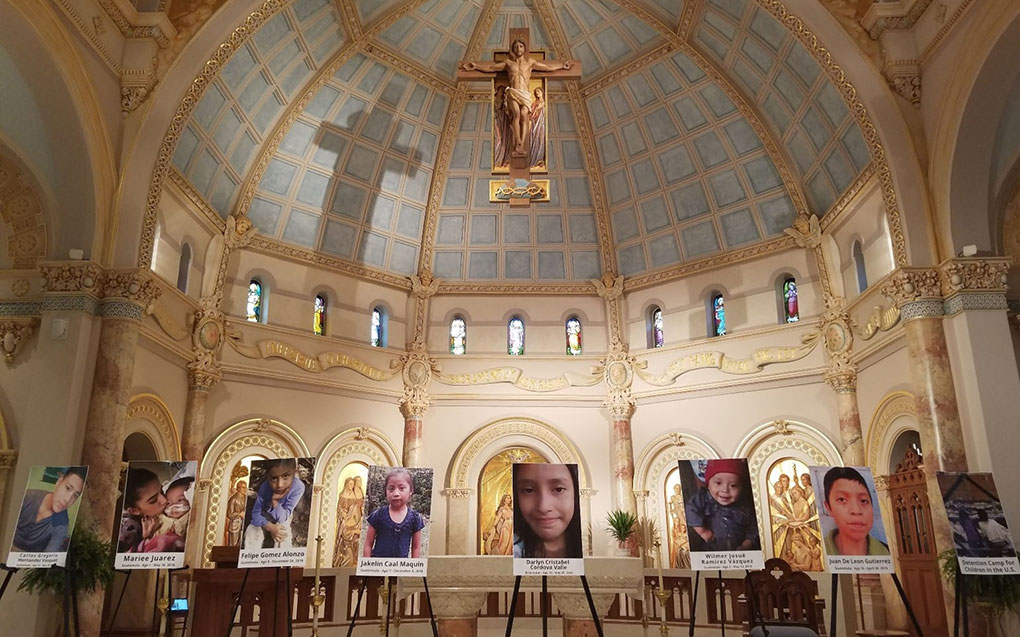 Interior shot of UIW Chapel with photos of immigrant children on tripods.