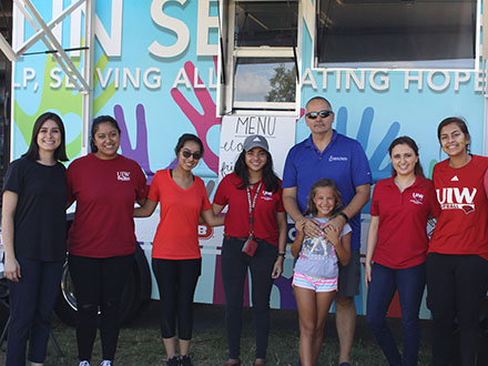 a group of UIW students and Alumni standing in front of a food truck