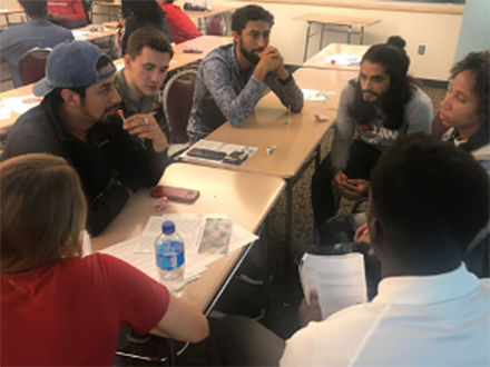 a group of student athletes having a group discussion at a table
