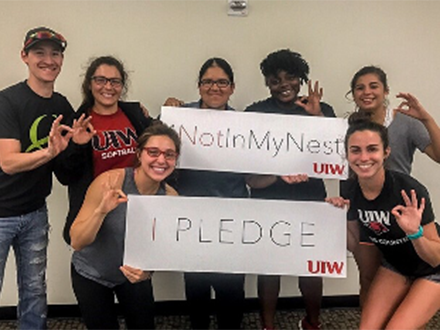 a group of student athletes posing with signs that say, "not in my nest"
