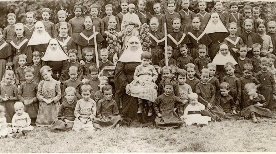 Nun posing with children- black and white