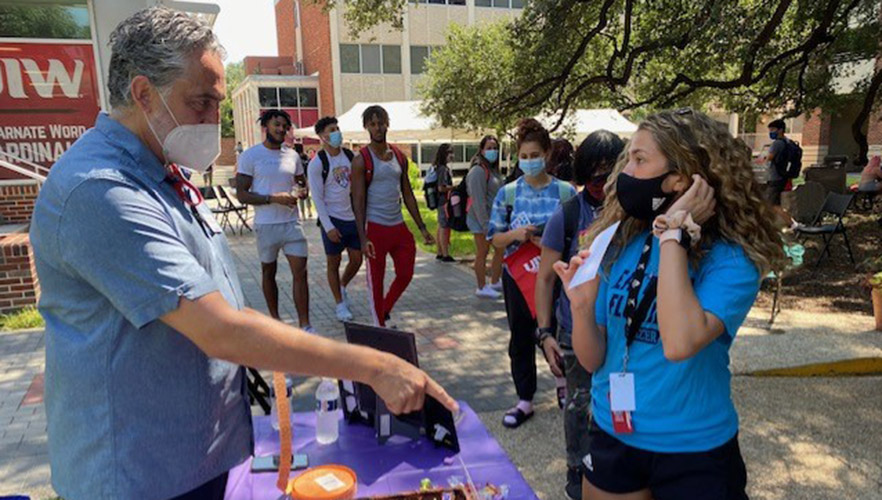 Students at a hand out table in the UIW quad