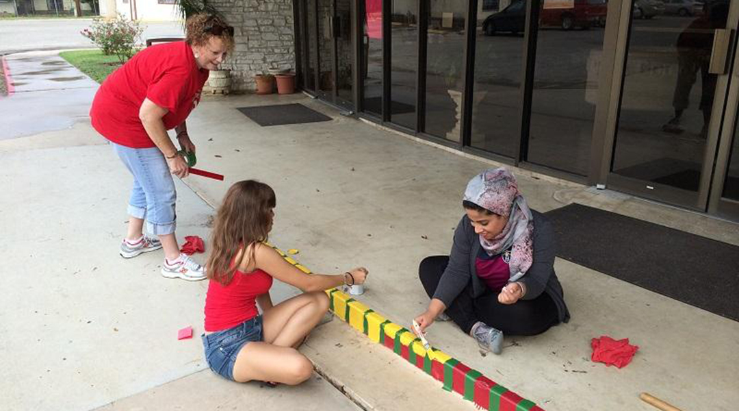 Students painting a sidewalk