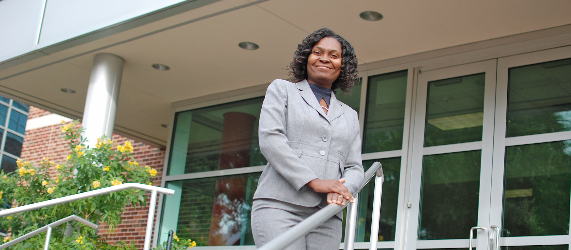 Student smiling in front of building