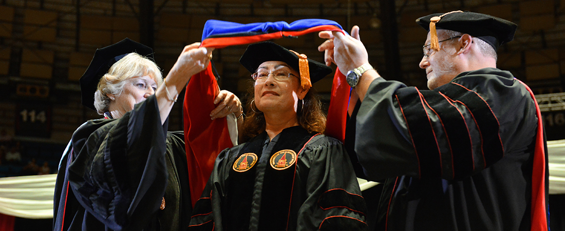 Dean and director hooding student at graduation