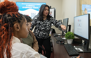 Financial aid office helping students on a computer