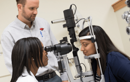 Optometry students interacting with clinical tools