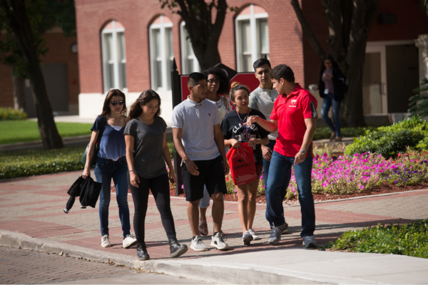 Potential UIW students in a group tour on a bright and sunny day.