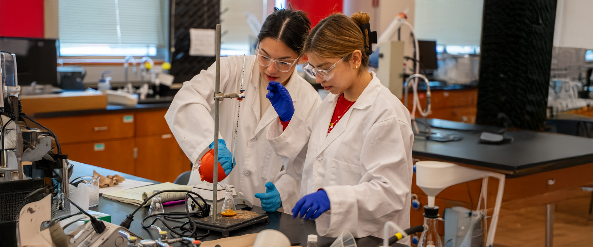 Two students practicing in the chemistry lab