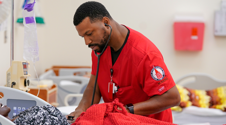 Male nurse tending to a bed in a simulation