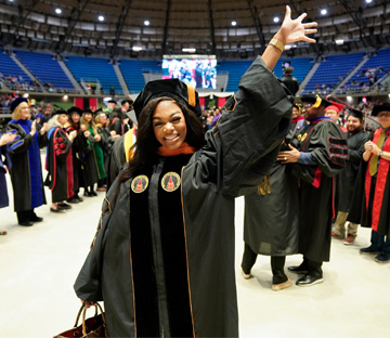 Very happy graduate student waving