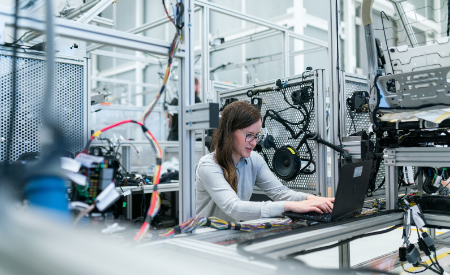 woman working on laptop in car lab