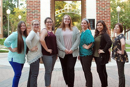 group of education students in front of the campus clocktower