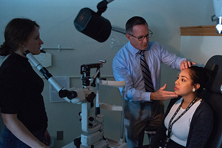 optometry instructor and student conducting a vision exam