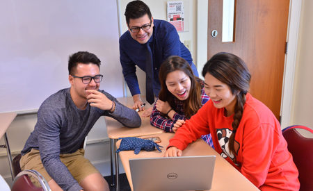 Group of students looking at a laptop