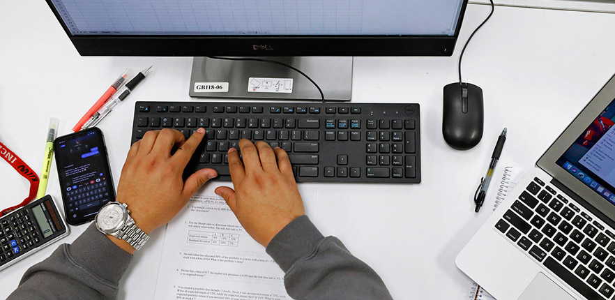 Student studying accounting with computer and calculator