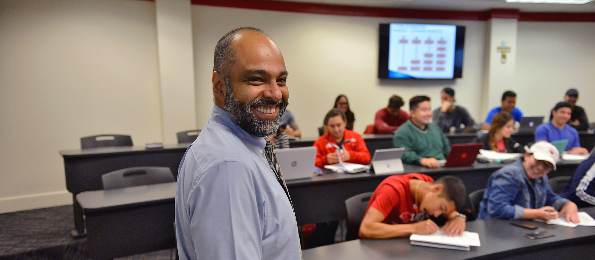 Professor in class smiling at the camera