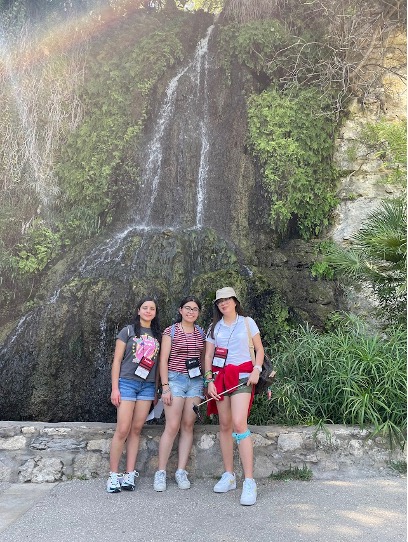 students standing in front of a waterfall