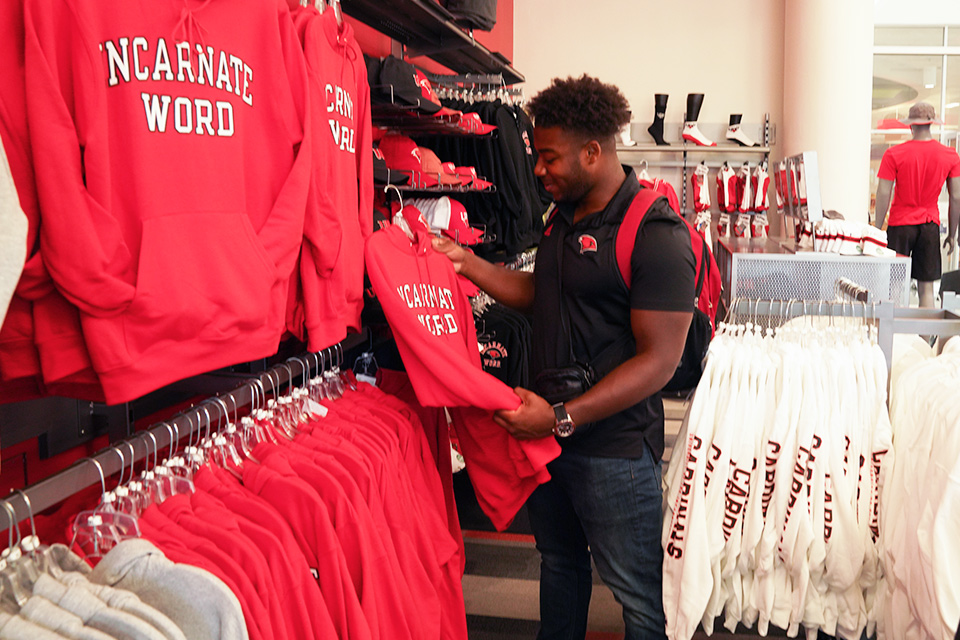 Man looking at sweaters at bookstore