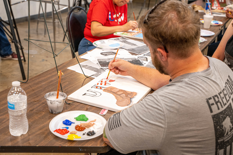 Male student veteran painting a canvas