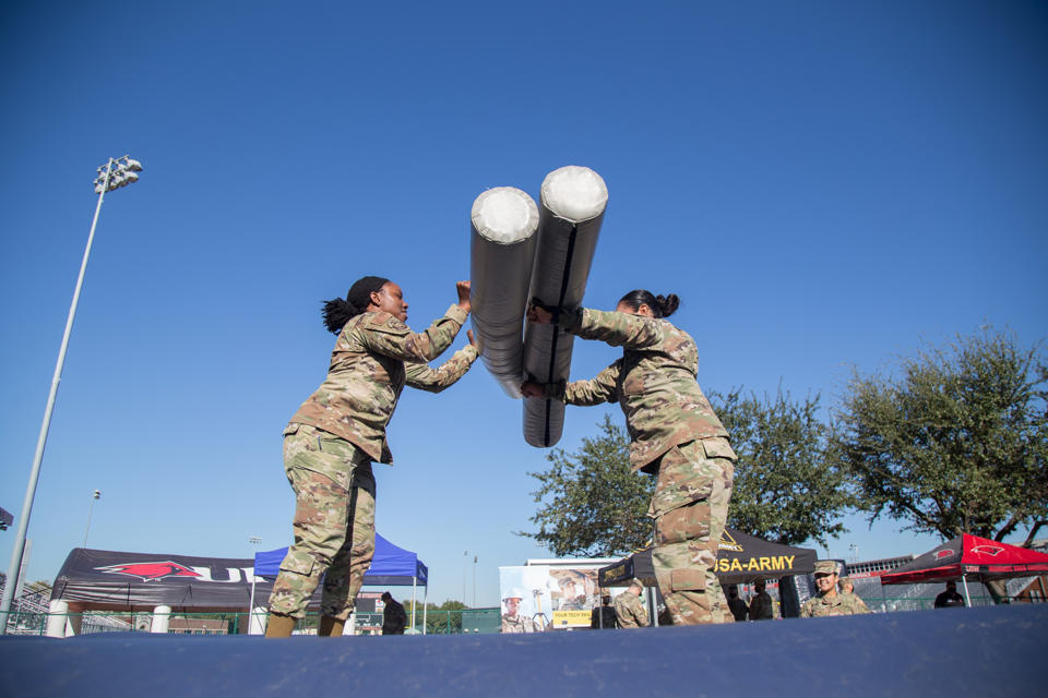 Two people in uniform playing inflatable jousting