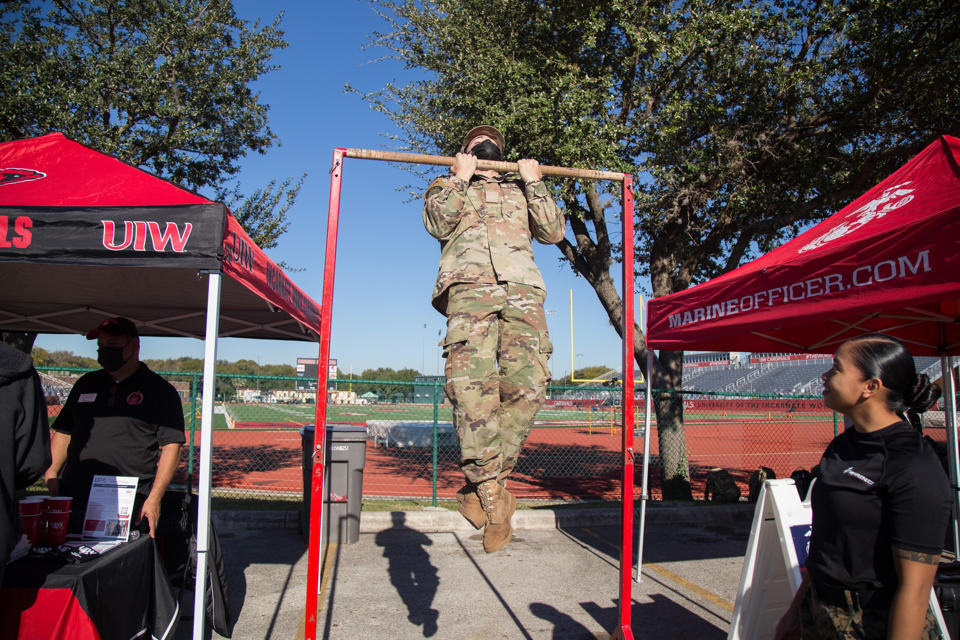 Person in uniform using pull up bar
