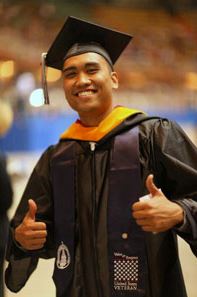 Male veteran student showing thumbs up in a graduation gown
