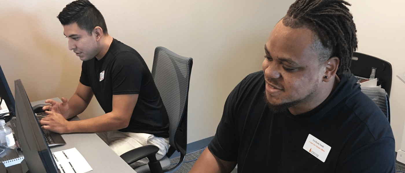 Two veteran student workers sitting at the front desk.