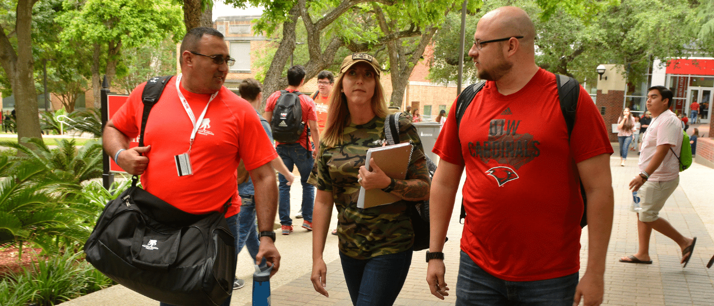 Three military veteran students walking outside on campus