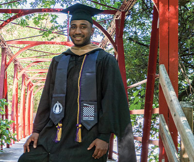 A veteran man wearing a gown and veterans stole on the UIW campus.